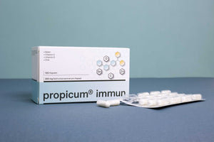Verpackung, Kapseln und Blisterpackung von propicum immun auf blauem Hintergrund