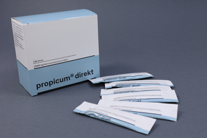 Ein Karton mit propicum direkt sowie die einzelnen Sticks liegen auf blauem Hintergrund