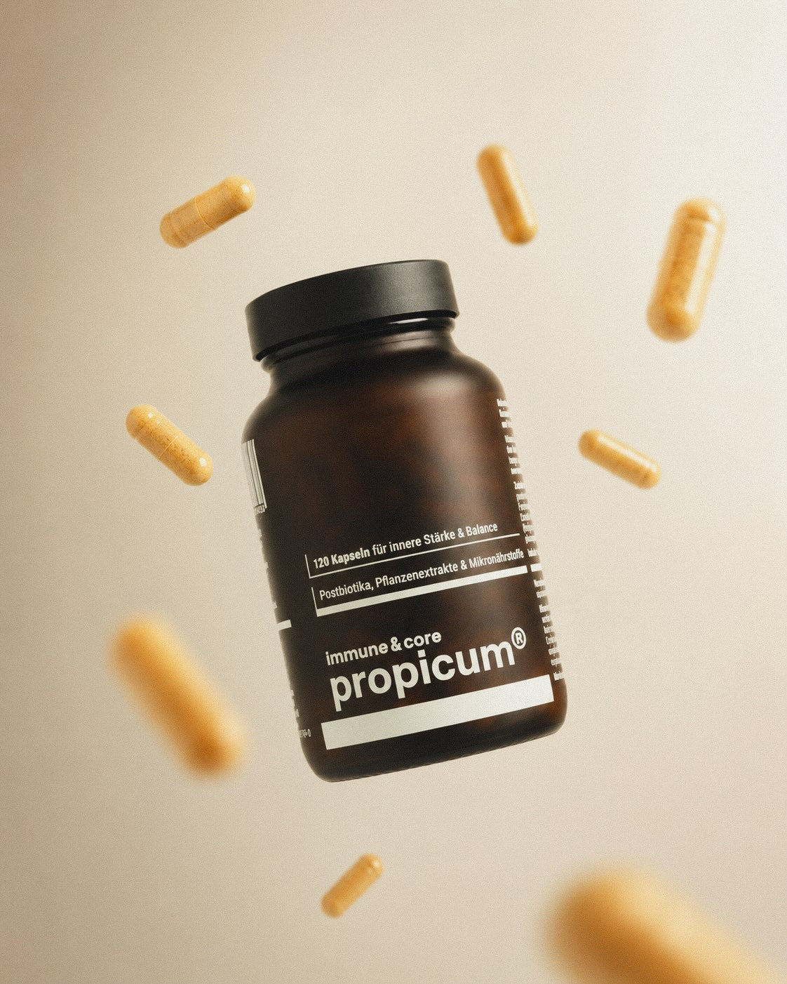 Kurkumafarbene Kapsel schweben um eine braune Glasdose mit propicum immune & core