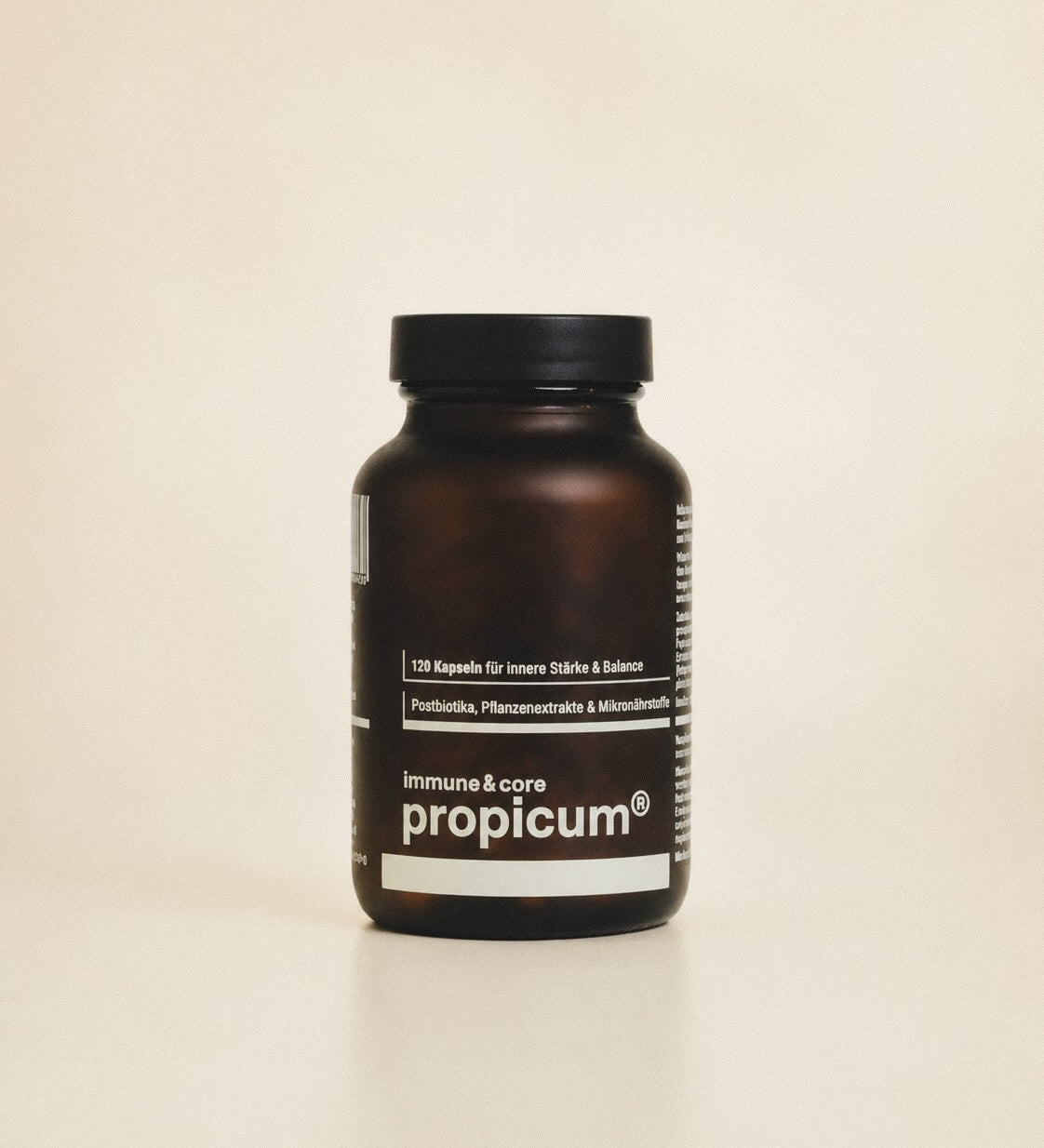 Dunkelbrauner Glasbehälter mit propicum immune & core steht vor beigem Hintergrund